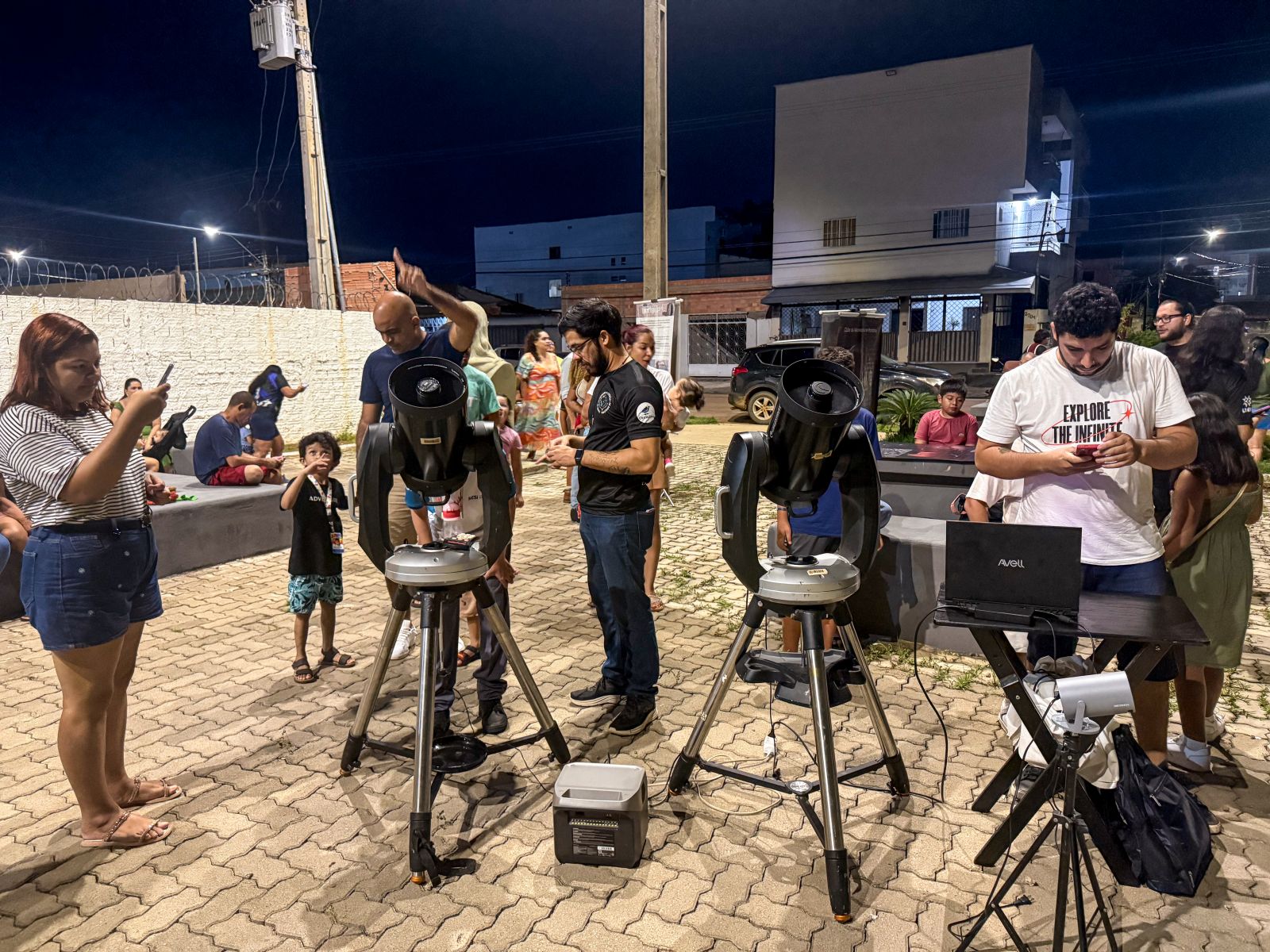 Com telescópios montados na praça e imagens de galáxias e planetas sendo apresentadas ao público